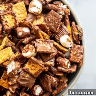 Overhead shot of snack mix in a bowl on a white counter.