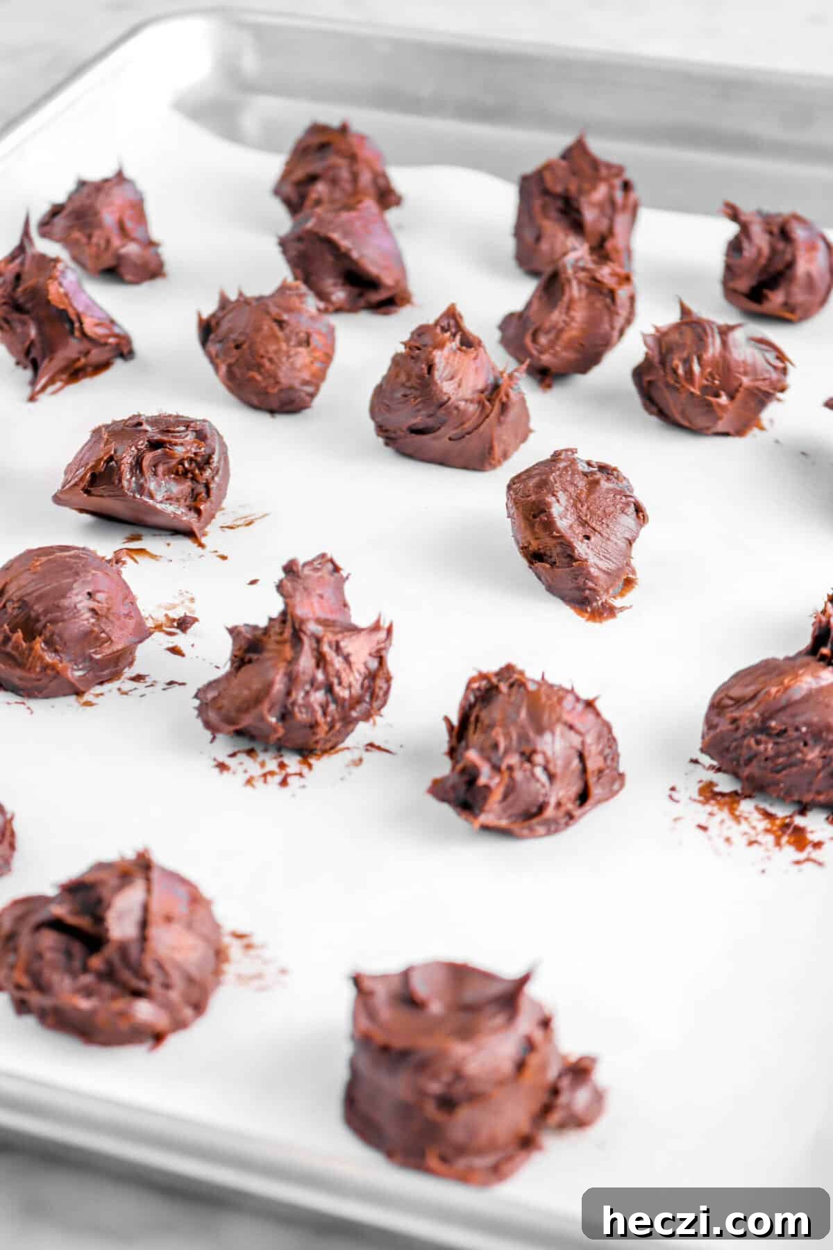 Red Velvet Molten Lava Cupcakes: Gooey Chocolate Center Delight 6 truffle filling scoops on lined pan.