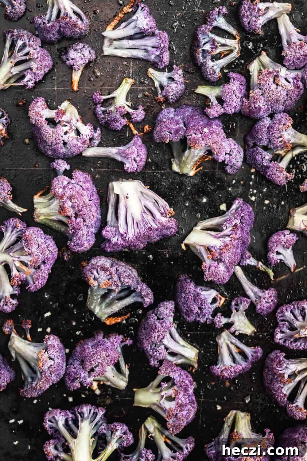 Roasted cauliflower post oven with a nice char on it on a sheet pan.
