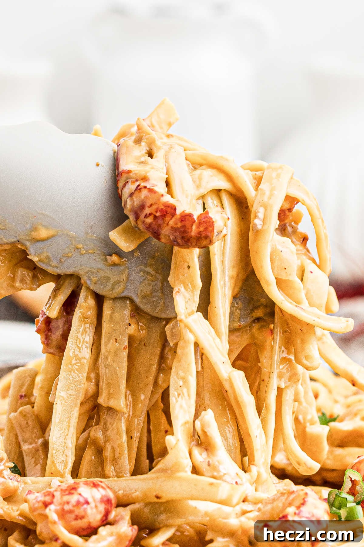 Creamy Crawfish Fettuccine with Garlic and Parmesan 12 very close up view of tongs picking up crawfish fettuccine