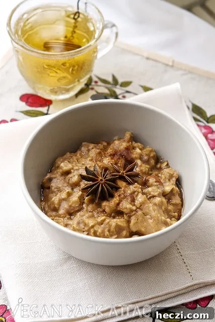 Close up shot of a bowl of almond chai oatmeal, on a linen with cup of tea