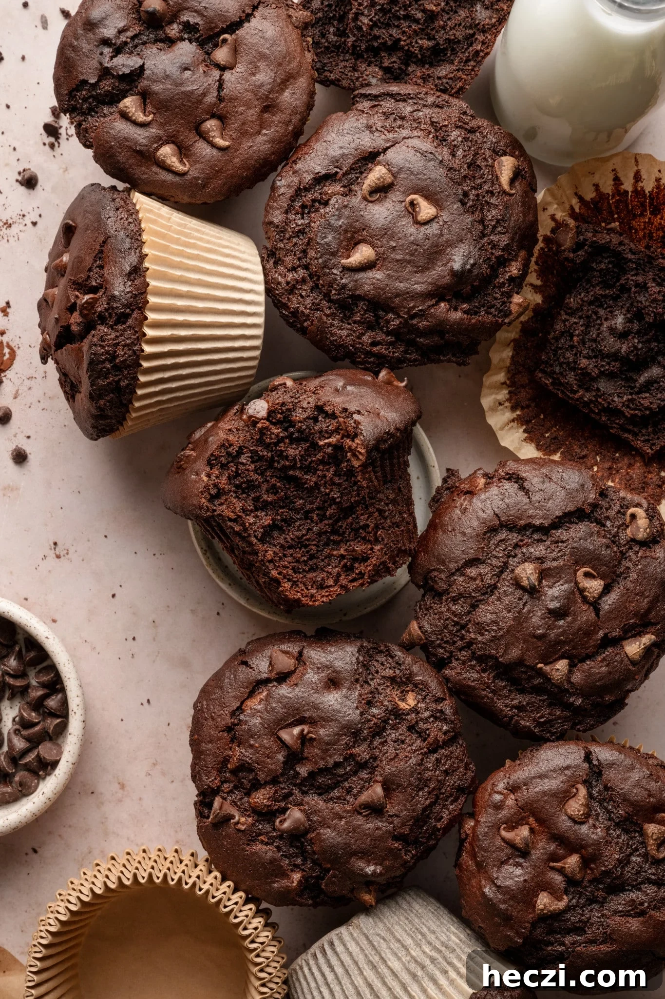 Costco-Style Double Chocolate Muffins Recipe (Copycat) 12 Plate of double chocolate muffins on board with glass of milk and bowl of chocolate chips on the side.
