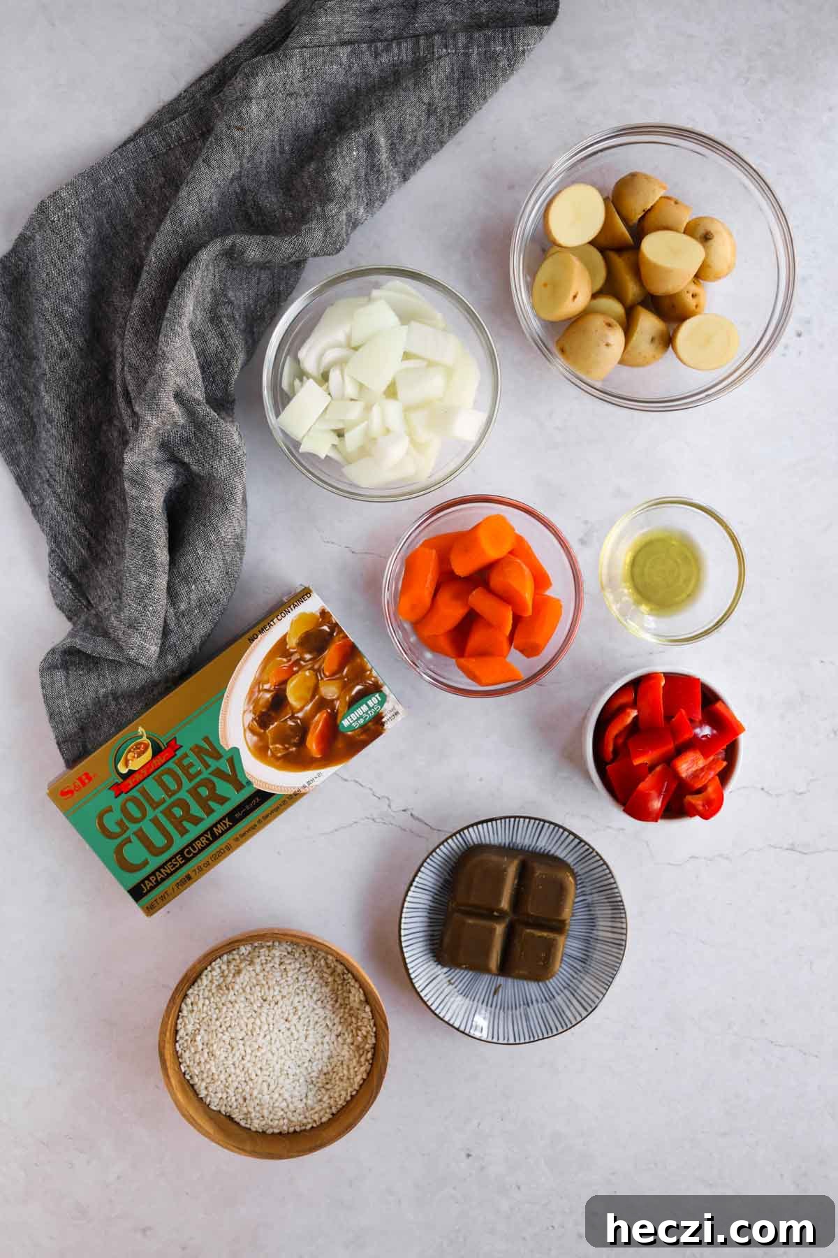 Japanese Chicken Katsu Curry Recipe — Crispy Cutlet with Rich Curry 3 Katsu Curry Ingredients in glass bowls, including chopped onion, carrot, bell pepper, potatoes, golden curry blocks, and rice