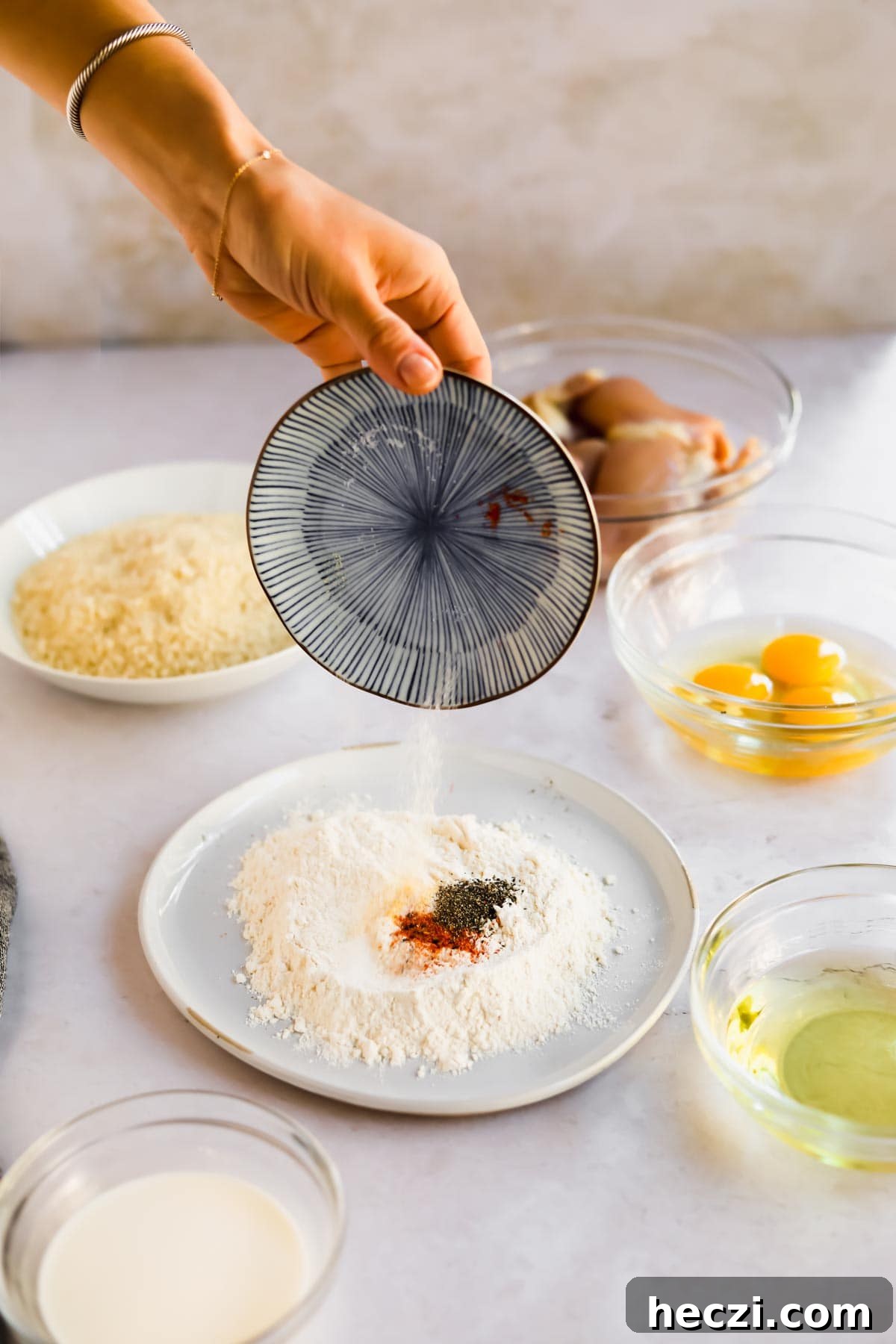 Japanese Chicken Katsu Curry Recipe — Crispy Cutlet with Rich Curry 8 Hand pouring seasoning into flour for Chicken Katsu dredge mixture