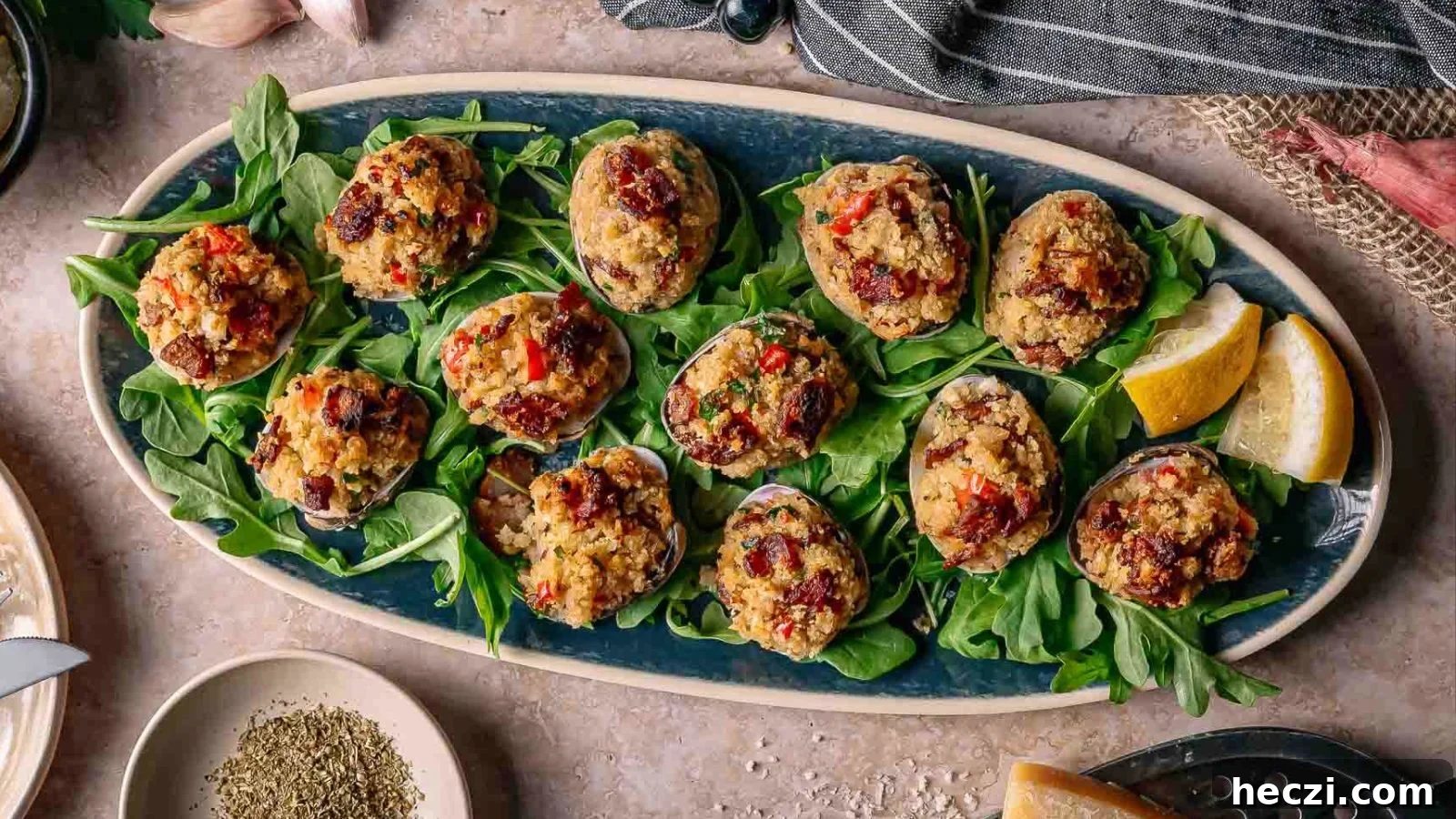 Clams casino baked with buttery breadcrumbs and herbs arranged neatly on a metal tray.