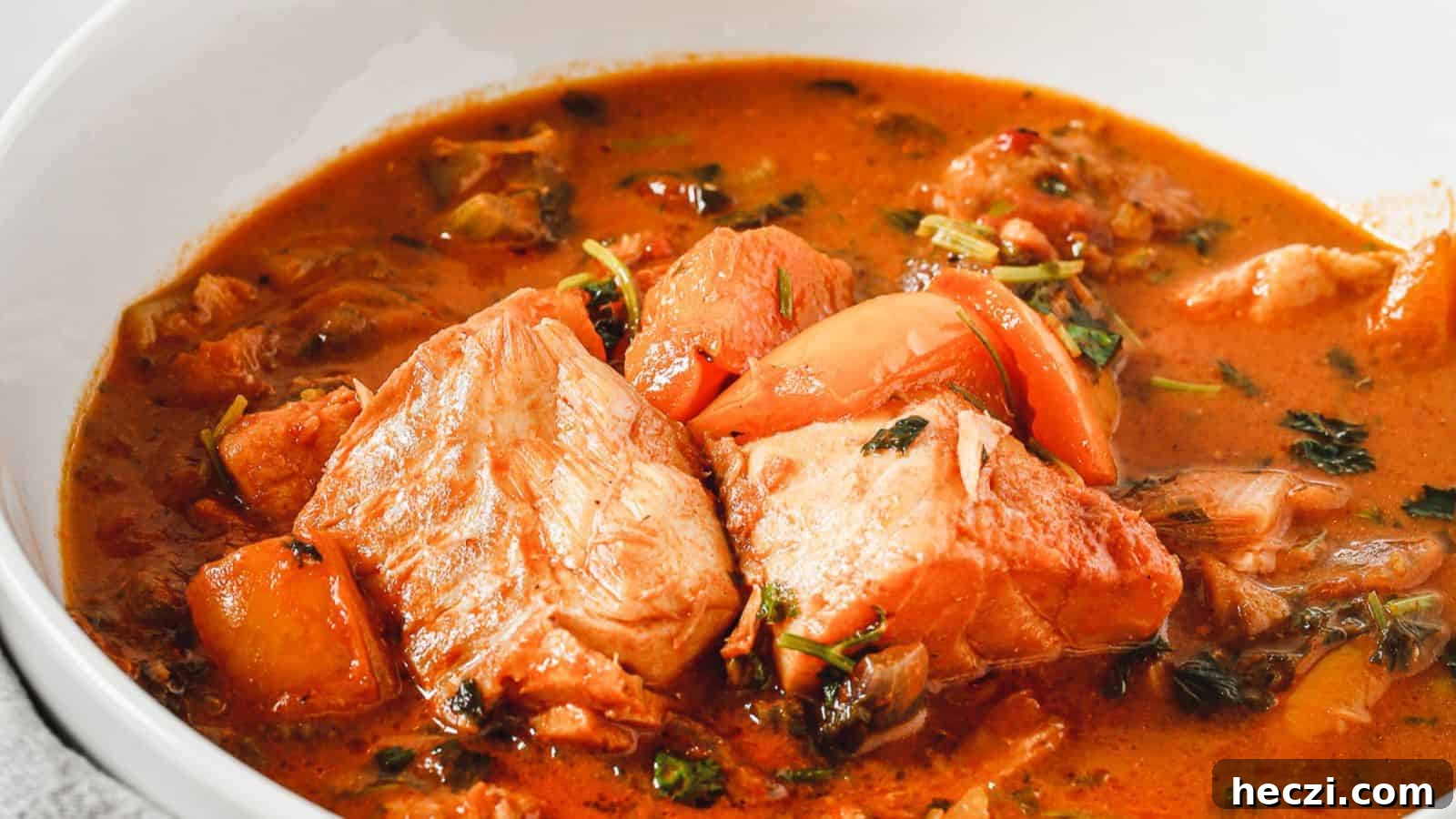 A bowl of stew with fish in it.