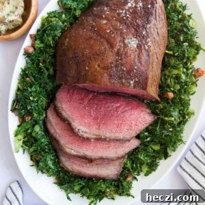 Perfect Picanha Roast Recipe for Juicy, Crispy Crust 14 a half-sliced Picanha Roast on top of sauteed greens surrounded by other side dishes before serving