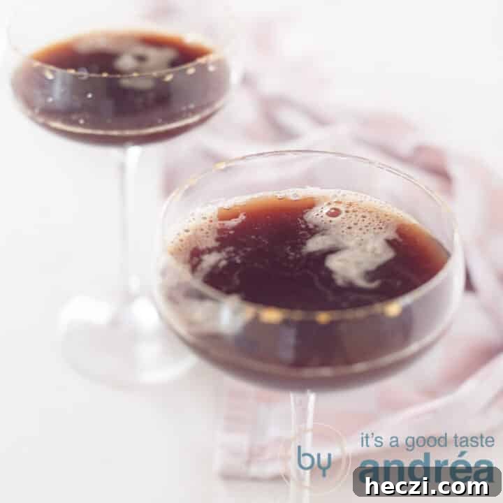 A square photo with two champagne flutes filled with a cold-brew coffee liqueur. A pink white tea towel in the background