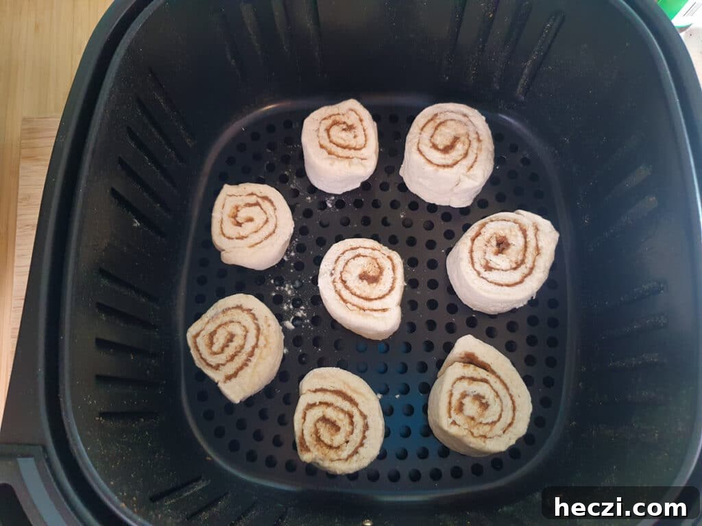 Air Fryer Cinnamon Rolls: Quick, Fluffy Homemade Recipe 12 Putting rolls in air fryer basket to bake.