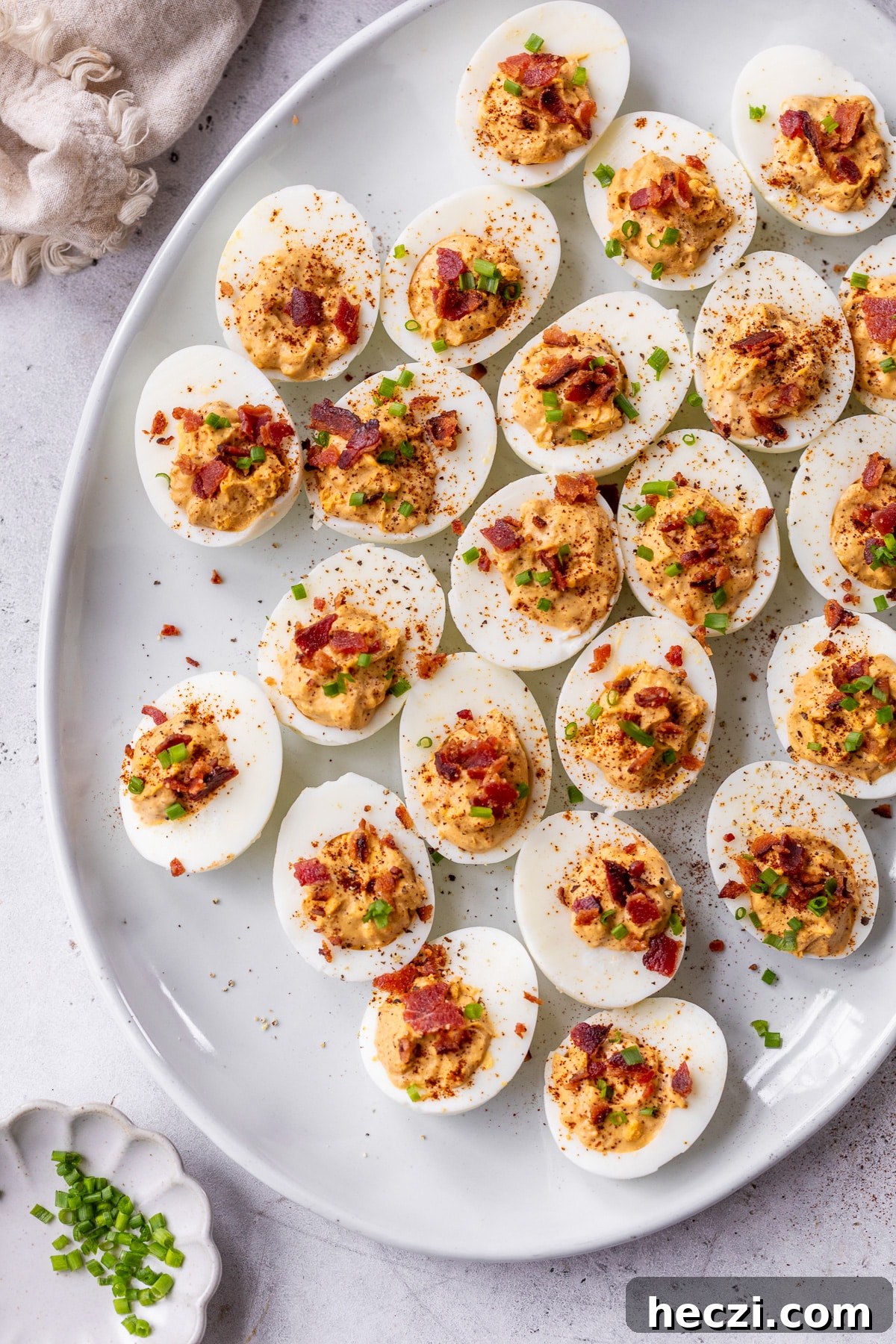 overview of chipotle deviled eggs topped with chives on a plate