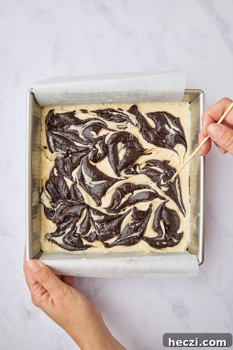 Fudgy Brownies with Cream Cheese Swirl Recipe 9 Dollops of brownie batter swirled into cream cheese layer with wooden skewer
