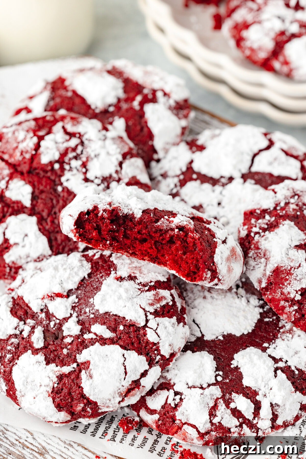 Red Velvet Crinkle Cookies: Soft, Fudgy Holiday Recipe 7 Red powdered cookies with cracked surface on parchment paper.