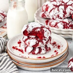 Red Velvet Crinkle Cookies: Soft, Fudgy Holiday Recipe 8 Red Velvet Cake Crinkle Cookies stacked on a plate with a bite taken out.