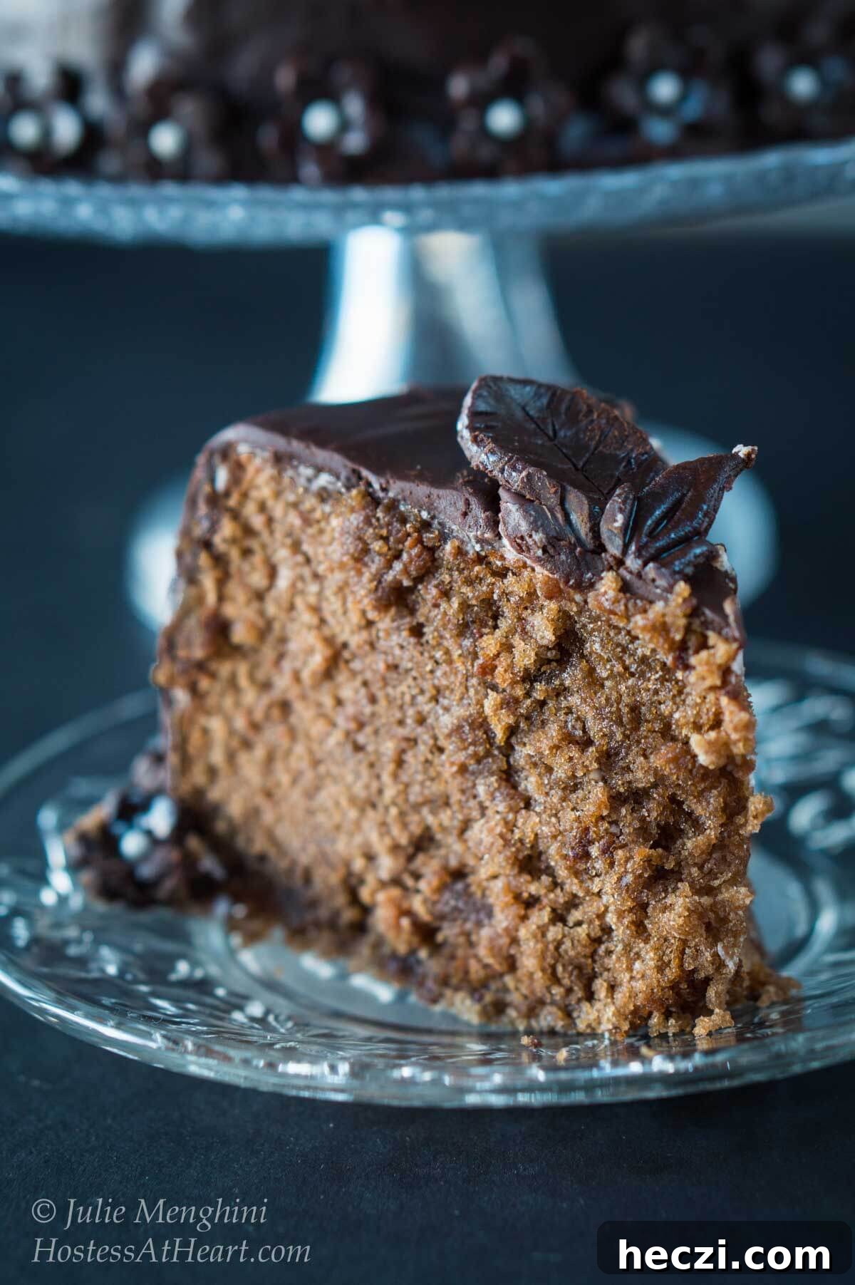 Black Russian Cake with Kahlúa Recipe: Rich Chocolate Cocktail Dessert 3 A piece of chocolate cake on a plate, topped with model chocolate flowers.