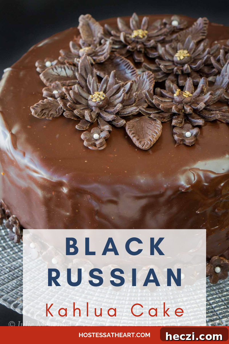 Black Russian Cake with Kahlúa Recipe: Rich Chocolate Cocktail Dessert 6 An angled view of a round cake covered in a shiny chocolate ganache and decorated with cutout chocolate flowers.