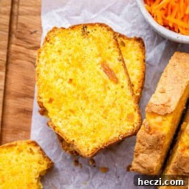 Extra-Moist Carrot Cake Loaf Recipe Packed with Flavor 8 Two slices of carrot cake loaf on parchment paper, with soft crumbs and visible raisins.