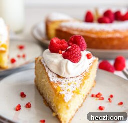 slice of french yogurt cake topped with whipped cream and raspberries.