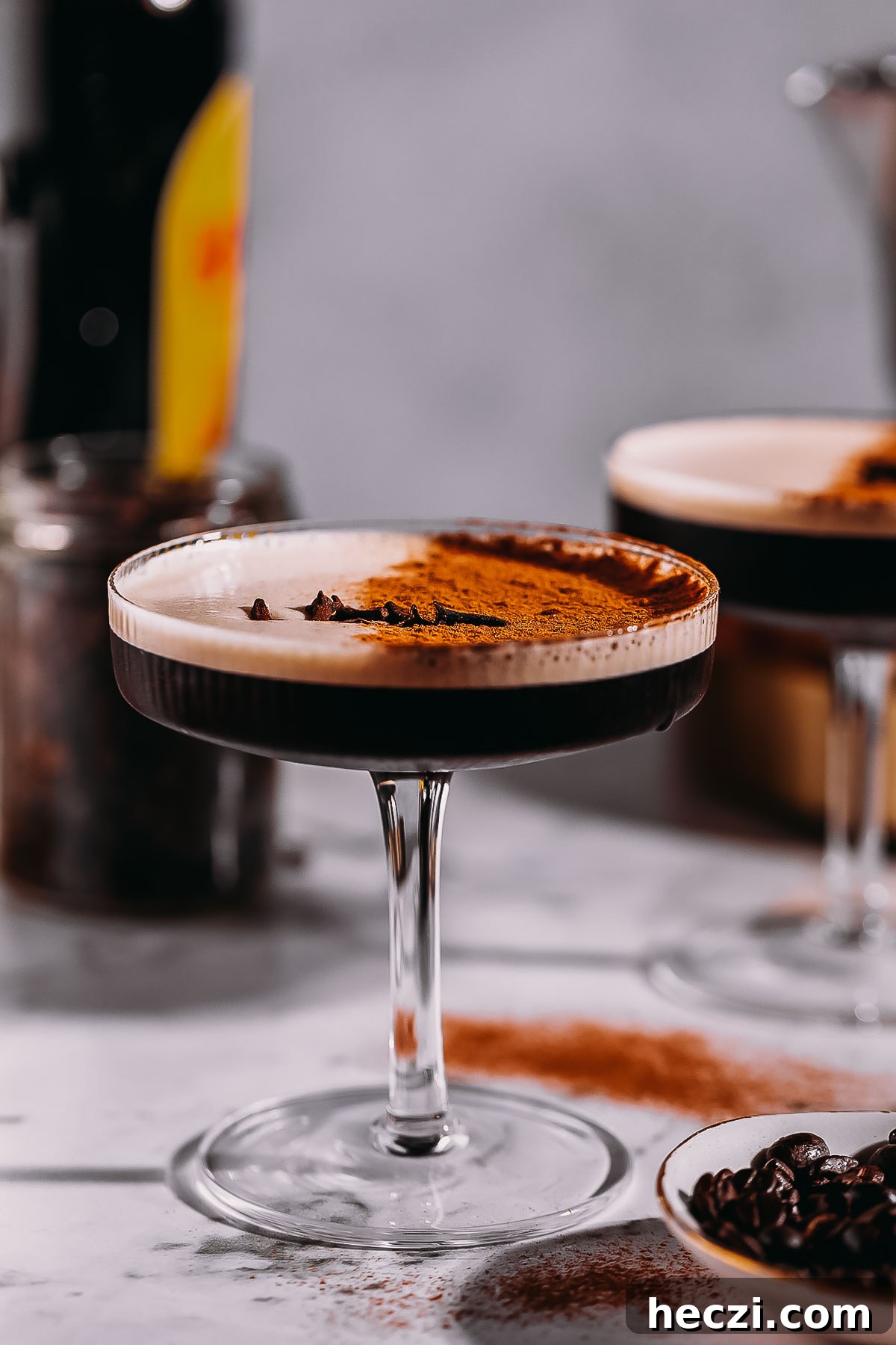 Side angle of a coupe glass filled with a frothy chai espresso martini.