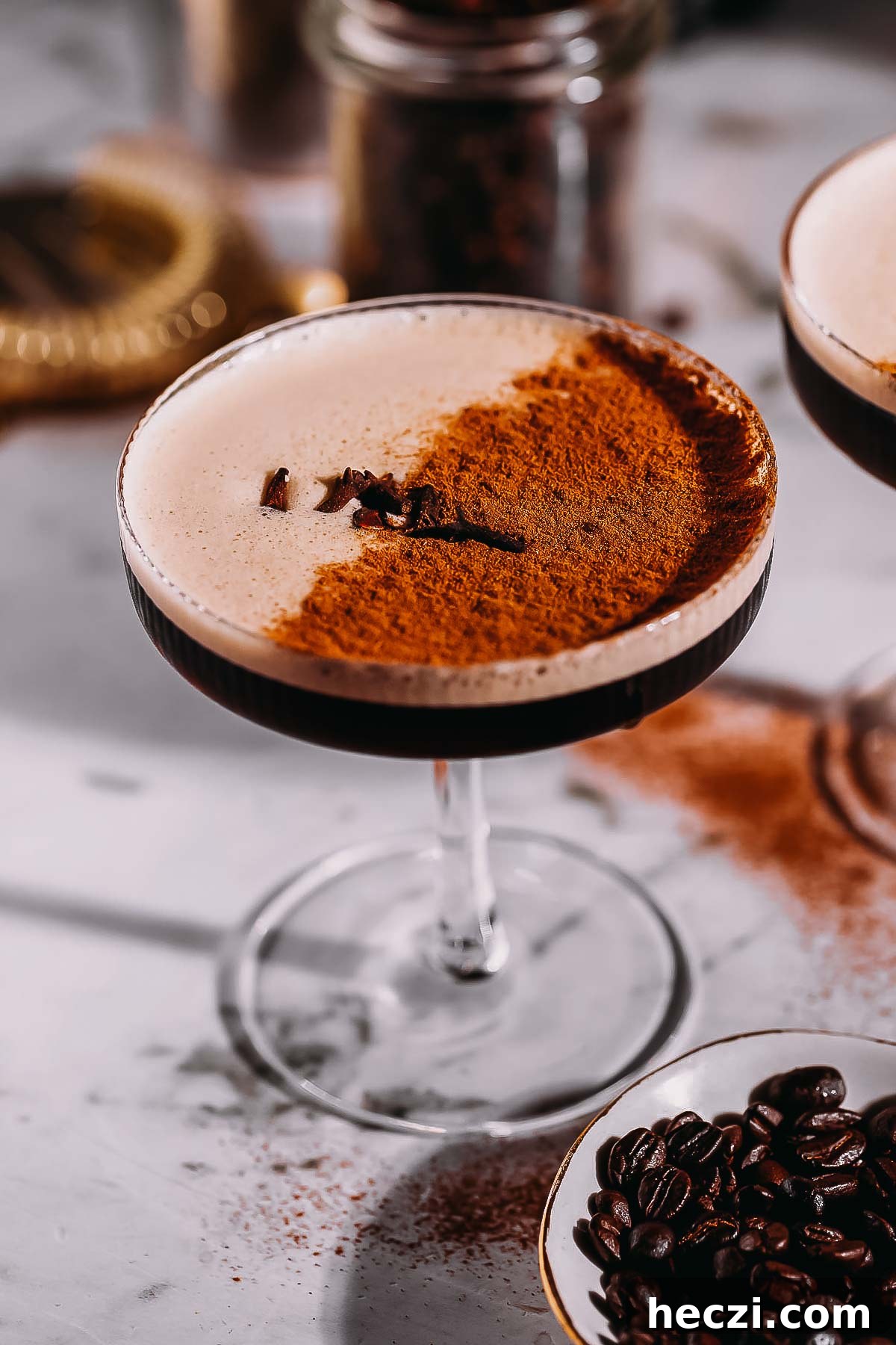 A coupe glass filled with a frothy espresso martini infused with chai spices.