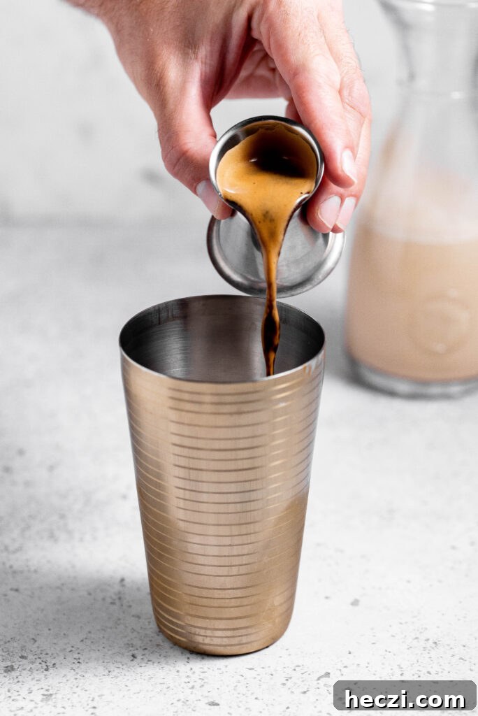 Espresso being added to cocktail shaker. 